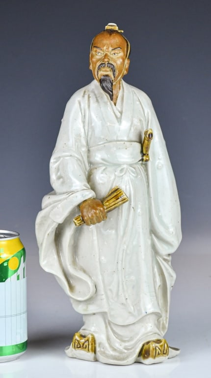 Wang Jing A Shiwan Kiln Figurine 20thC: A Shiwan figure depicting a standing male figure in robes, holding a scroll in one hand, marked with the artist's seal on the inner base. H:32.5cm 王經(20世紀)