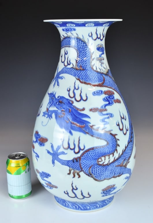 A Blue White & Under-Glazed Red Vase 1950-70s: With a pear-shaped body rising from a straight foot to a tubular neck and everted rim, painted with a dragon surrounded by cloud motifs, a six-character Qianlong mark at the base. H: 48.5cm 