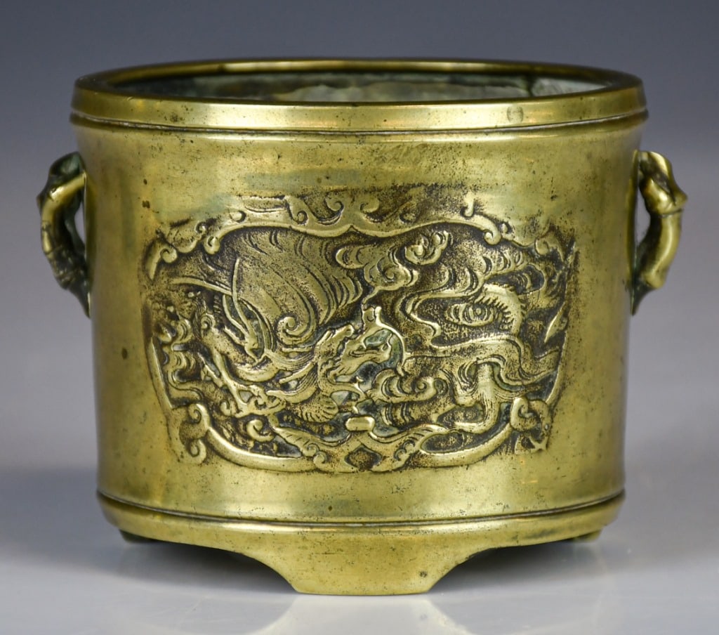 A Bronze Cylindrical Tripod Censer Qing: Of cylindrical form, the censer exterior front and back molded with mythical beast, flanked by pair of bamboo handles, H:8.6cm, D:11.7cm 清 雙耳瑞獸紋銅ཛྷ