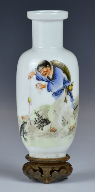 A Famille Rose Vase w/Std: The cylinder body rising from a short foot, with a straight neck and a wide flaring rim, painted with a scene of a man and a toaster. H: 15.3cm 粉彩人物紋棒槌