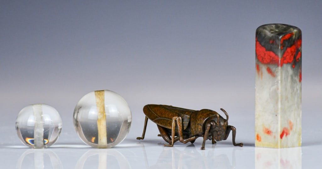 Group of 4Pcs Antique Objects: Comprising 2 pieces glass balls for official hat, bigger D:36.8cm, a seal stone H:76.8cm, a bronze cricket L:8cm 各式老物件一組4件 Click here