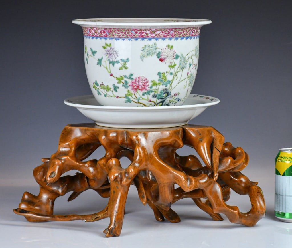 A Famille Rose Flower Pot Marked w/Std Republican: Rising from a short foot, painted with blooming flowers in a garden scene with two bats, fitted with a drainer and a carved wood stand modelled in the form of intertwined branches; Jingdezhen mark on