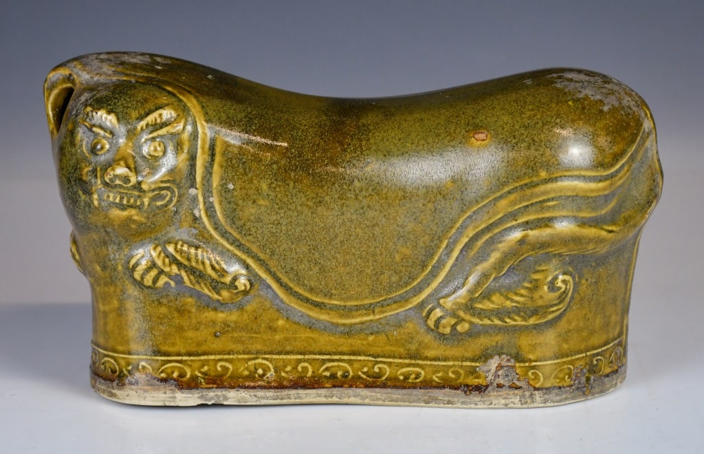 An Archaistic Brown-Glazed Tiger Pottery Pillow: The pillow is robustly modeled in the form of a recumbent tiger, exterior is dressed in a rich, variegated amber-brown glaze of olive tones, stopping short of the flat, L:26cm, H:14cm 高古
