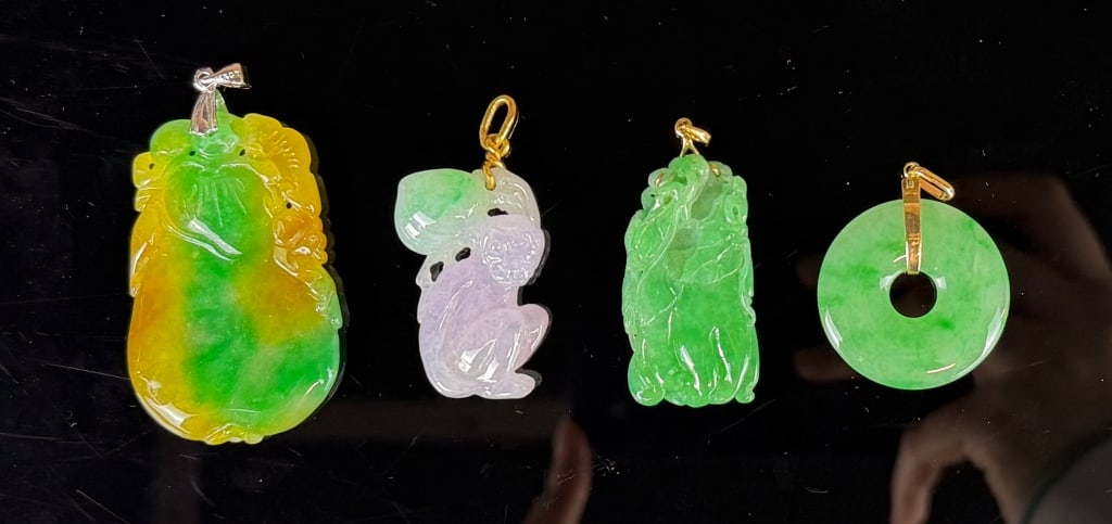 Group of 4Pcs Jadeite Pendants: Comprising 4 pieces jadeite carved pendants in various colors and themes, the largest :5x3.2cm 翡翠掛件一組4件 Click here for natural light photos
