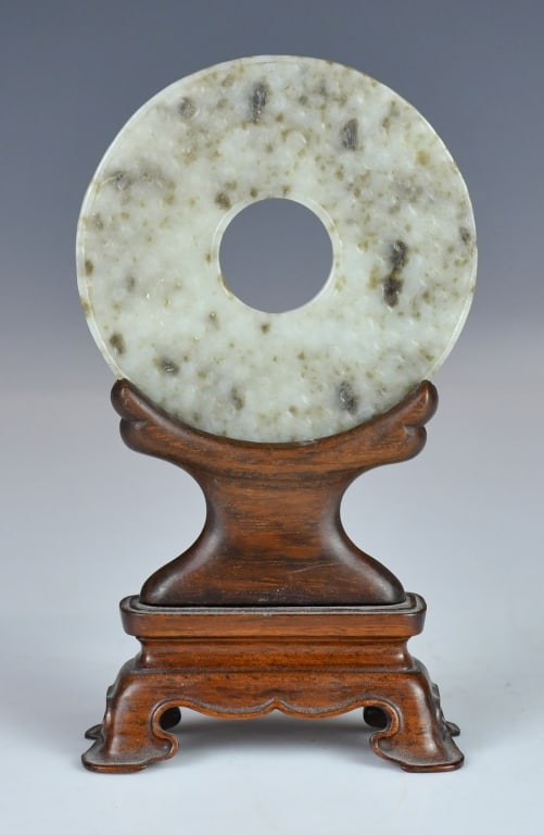 An Archaistic Jade Bi Disc w/Std: Of circular form with a central aperture, carved with patterns on each side, overall in greyish and russet tone; comes with a wood stand. D: 9.5cm 高古風格谷紋ħ