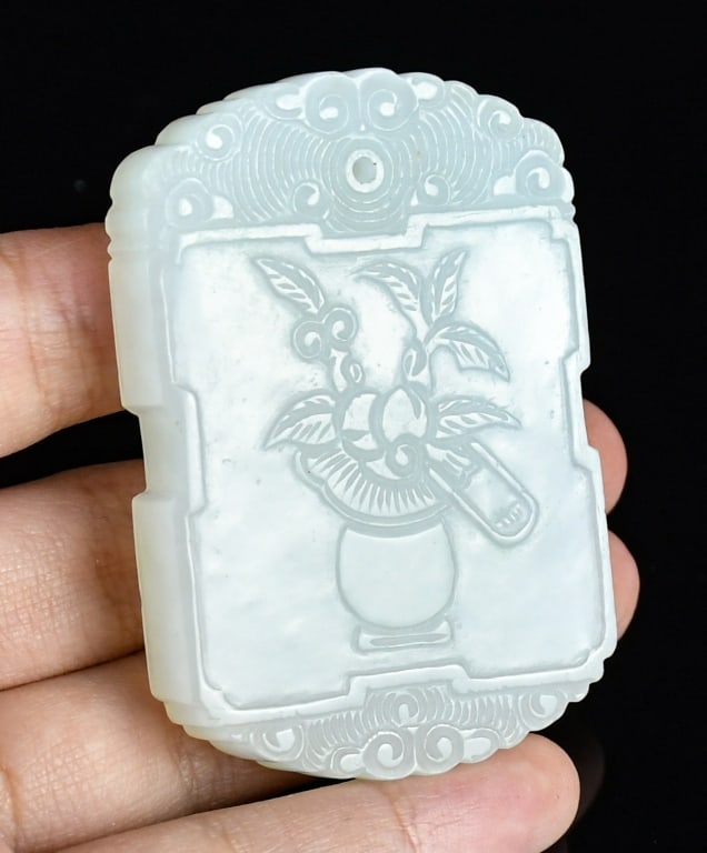 A Jade Inscribed Pendant Plaque Qing: A white jade plaque, one side carved with a flowering plant, the reverse inscribed, the stone of white tone. 3.9x5.8cm 清