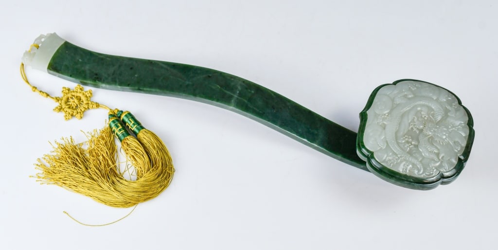 A Spinach Jade Ruyi Scepter w/ Carved Jade 20thC: It features a curved, smooth main body. The head is carved in a distinct, lobed shape, and the white jade plaque inset on top displays detailed relief carving of a dragon, L:44cm. Comes with a 