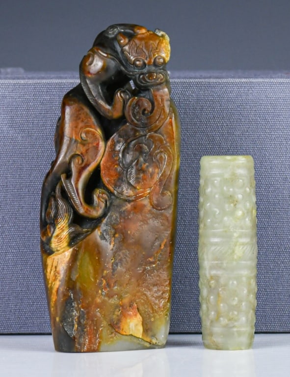 A Jade Carved Seal & A Jade Tube Bead: Comprising a carved jade seal H:11.5cm, and a jade tube bead L:6.6cm, the seal comes with a box. 玉印及玉勒子 連盒 Click here for natural