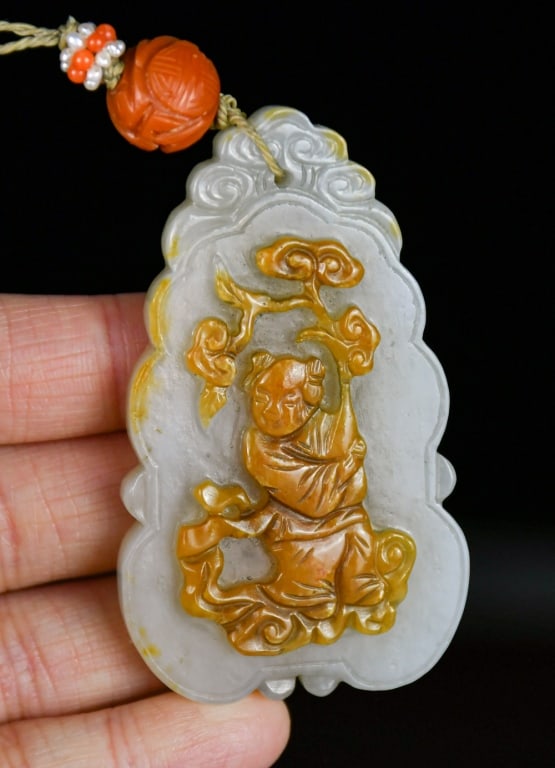 A Jade Carved Plaque Republican: Carved on one side with a figure in brown tone, the reverse incised with Chinese characters. The stone is of overall white colour with subtle brown inclusions, 6.7x3.9cm 民國