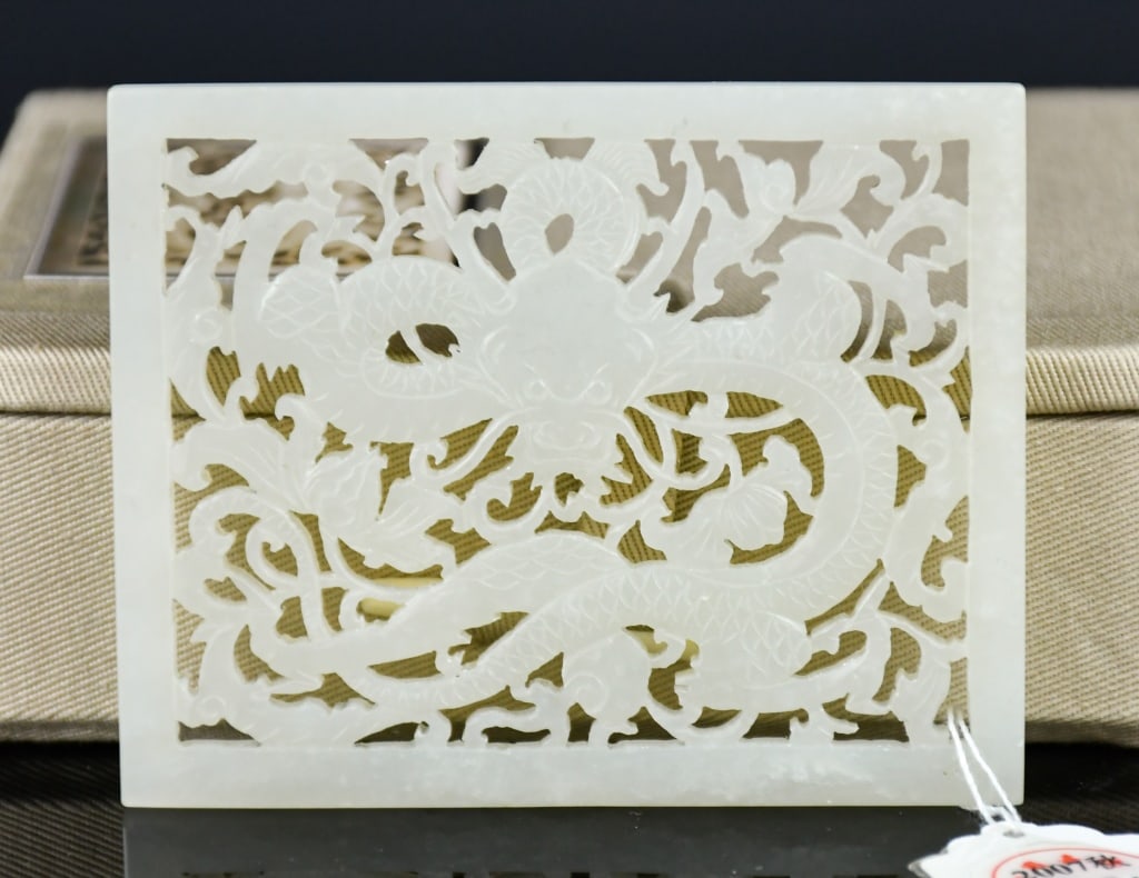 A White Jade Reticulated Plaque 19thC W/Certificate: A rectangle jade plaque, reticulated a dragon among leave scroll scene, the stone overall in pale celadon color tone, 8.5x6.7cm Provenance: Former collection of a Canadian company executive in