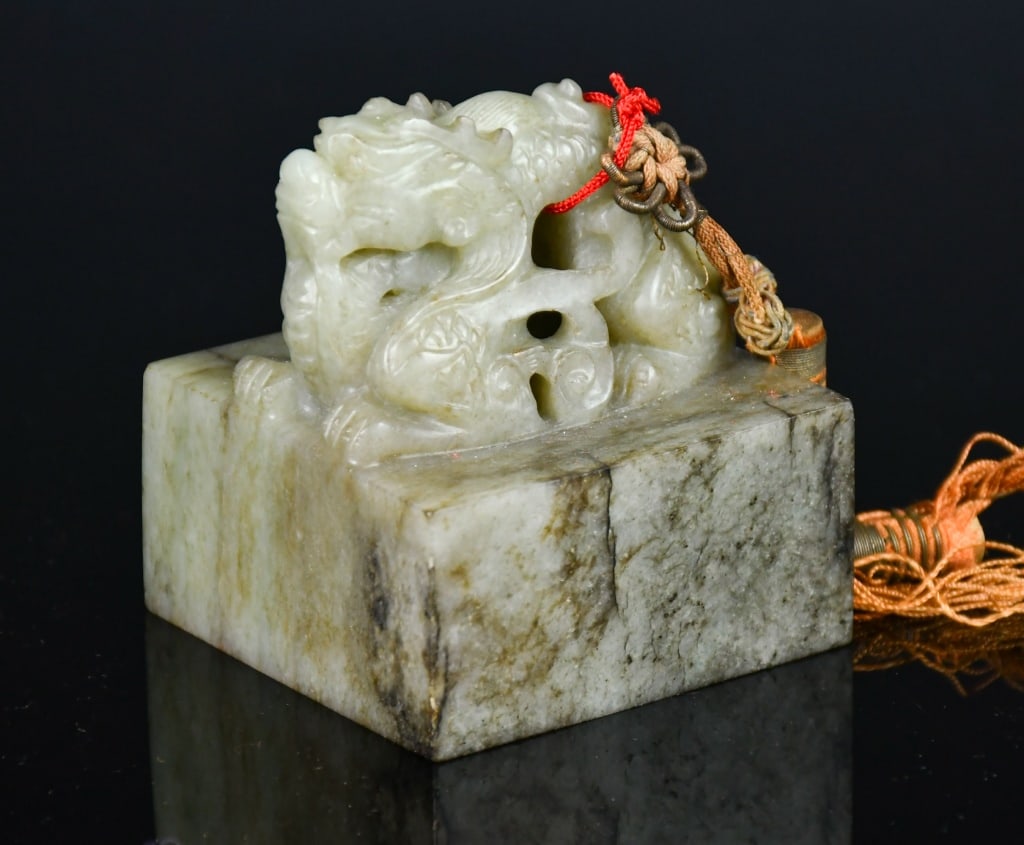 A Jade Carved Dragon Seal Republican: A large jade square seal with dragon carving on top, the stone overall in light grey color tone, 6.1x6.1x7.2cm 民國 玉雕龍璽 Click here for natural light
