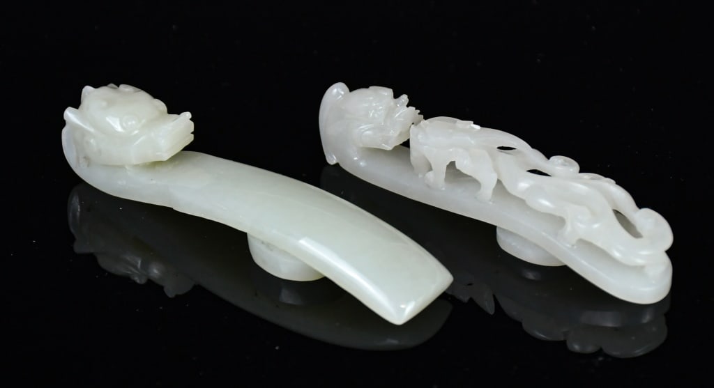 Group of 2 White Jade Dragon Belt Hooks Qing: Comprising two jade belt hooks in various designs, colors and sizes; one overall in white tone, the other one in pale celadon tone. Larger L: 9cm 清