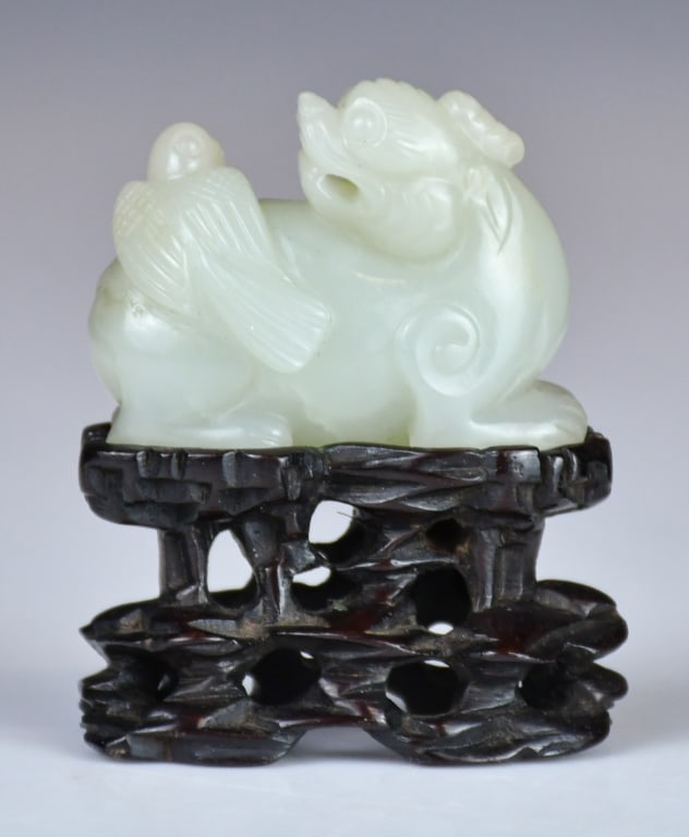 A White Jade Carved Beast w/Std Qing: Depicting a recumbent mythical beast turning its head to look back at a bird perched on its back, the stone of overall light celadon tone. 4.5x3.7cm 清
