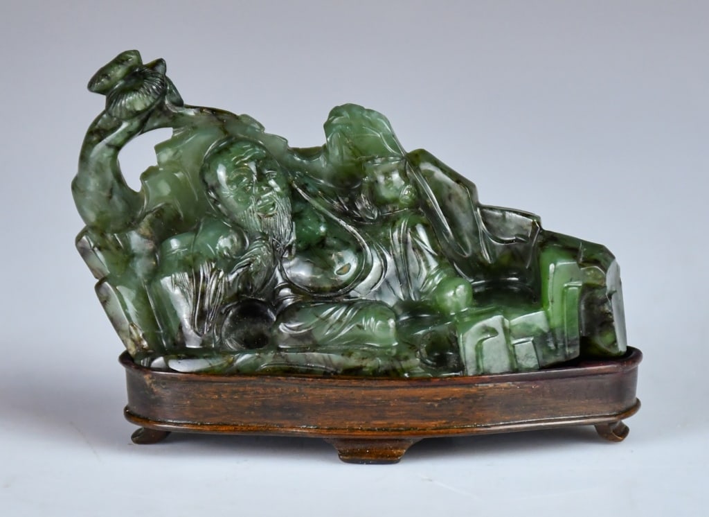 A Spinach Jade Carved Figure w/Std Republican: Depicting a figure reclining on its side, propped on one arm in a relaxed pose, the stone overall of dark green tone. 8x4.8cm 民國