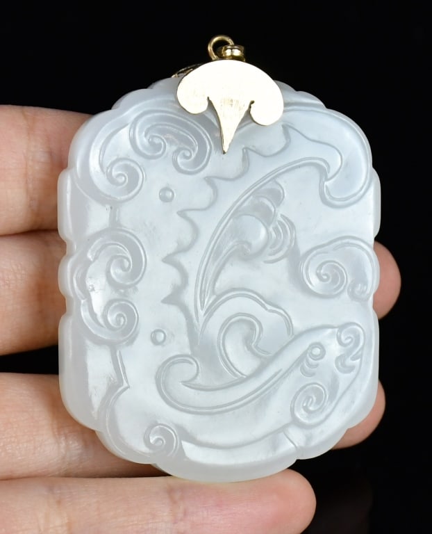 A 14K Gold Mounted White Jade Pendant Qing: A white jade carved plaque mounted with 14K gold, one side carved with decorative motifs, the other incised with Chinese characters. 5.5x4.3cm 清