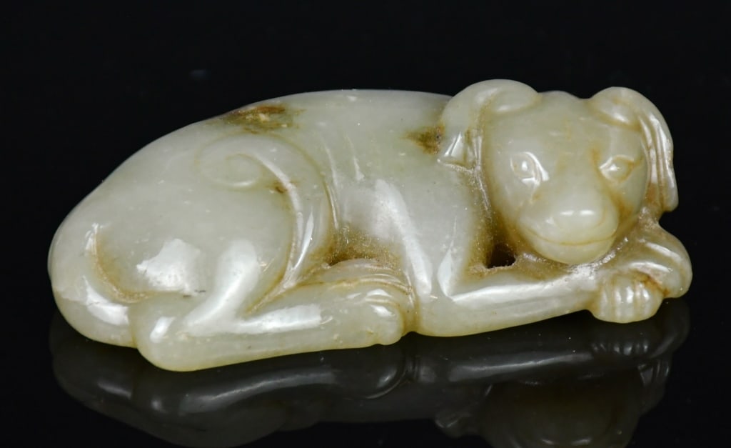 A Jade Carved Dog Qing: The jade is carved as a recumbent dog, with it's head on feet, overall in yellowish celadon color. 8.2x4cm 清 玉雕臥犬把件 Click here for natural