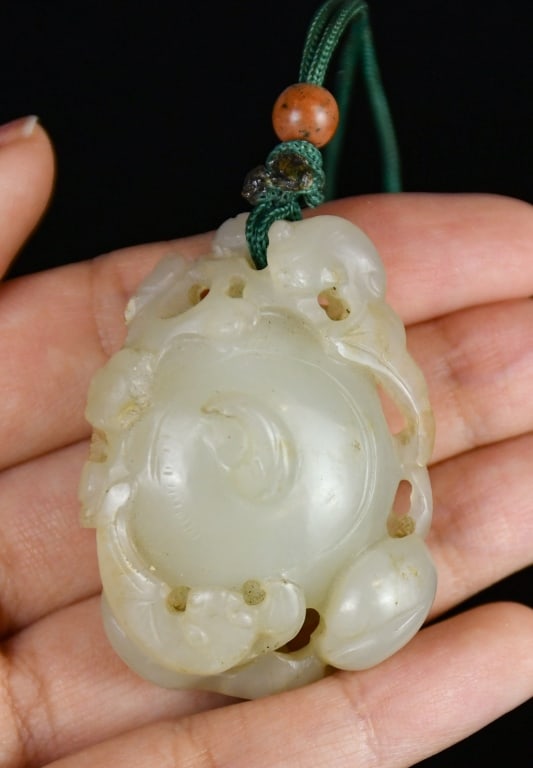 A White Jade carved Water Chestnut Qing: Carved from white jade as a water chestnut surmounted by bats and flowers, L:4.7cm 清 白玉雕荸薺把件 Click here for natural light photos