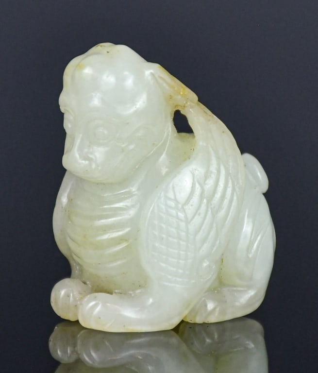 A Jade Carved Mythical Beast Qing: Carved as a sitting beast, overall in white tone with light russet shades. H:4.1cm 清 白玉雕瑞獸把件 Click here for natural light photos