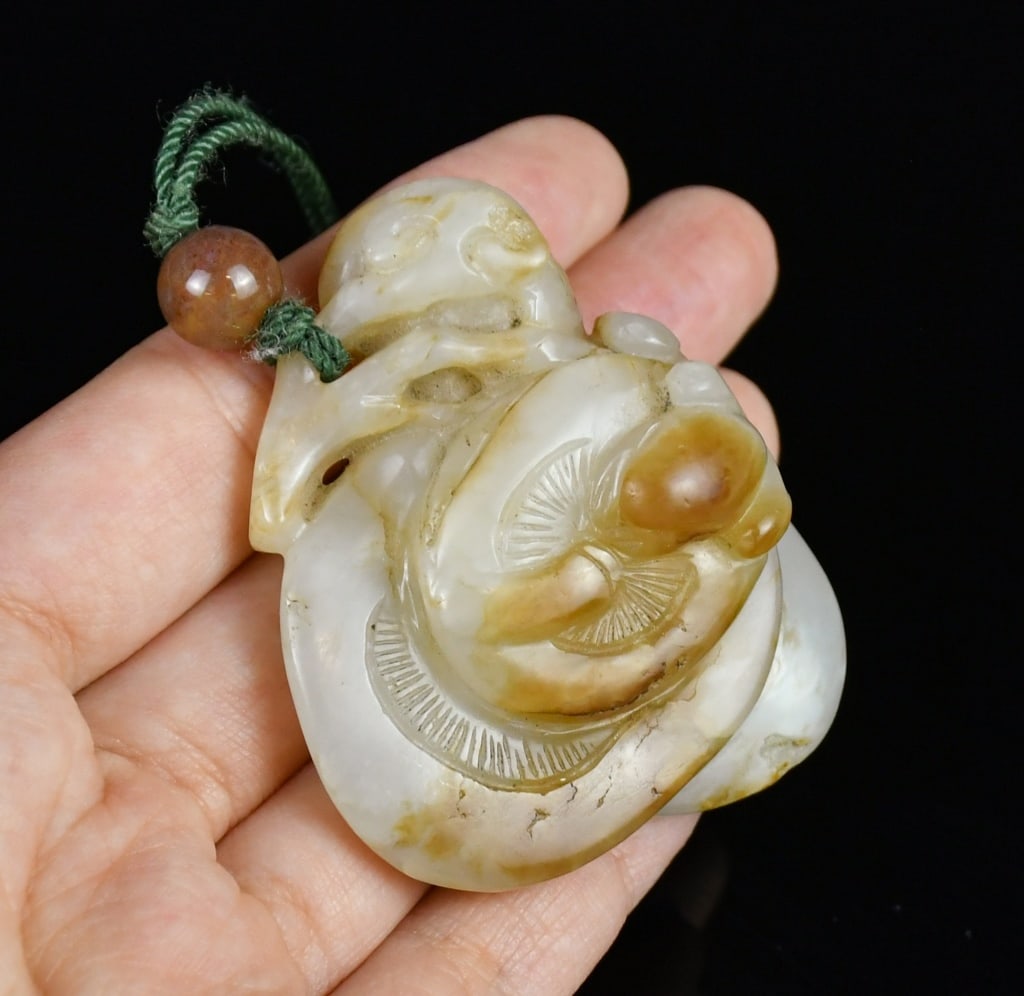 A Jade Carved Lingzhi Qing: A jade carved Lingzhi plant, the stone overall in rice white color with large part of beige inclusion, 5x4.5cm 清 玉雕靈芝把件