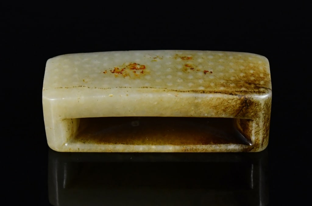 An Archaistic Celadon Jade Scabbard Slide: A celadon jade carved scabbard slide with grain pattern, L:6cm 高古風格青白玉劍飾 Click