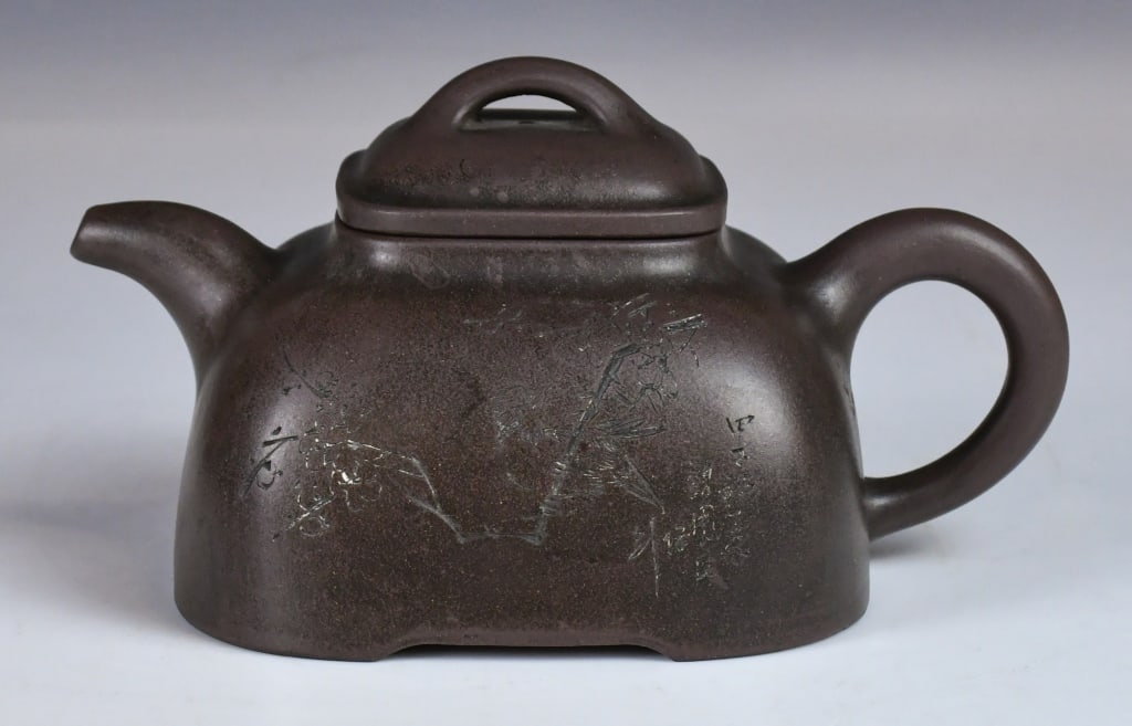 A Carved Stone Scoop Zisha Teapot: A classic Shipiao shape, the body is artistically incised with a plum blossom branch while the other side with inscription. Maker's mark at the bottom. D:18cm, H:9cm 陶淦生