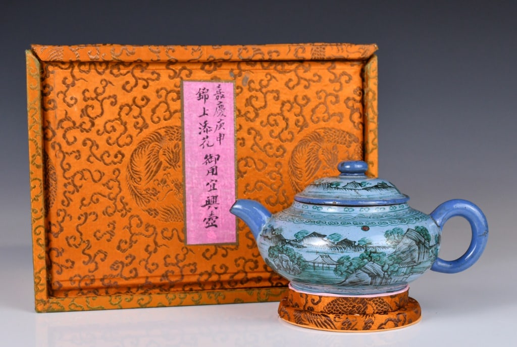A Yixing Zisha Teapot Jiaqing Mk w/Box: Painted overall to the body with a landscape scene, incised to the base with a four-character Jiaqing mark. D with handle & spout:16cm Provenance: Vancouver Hong Kong Immigration 