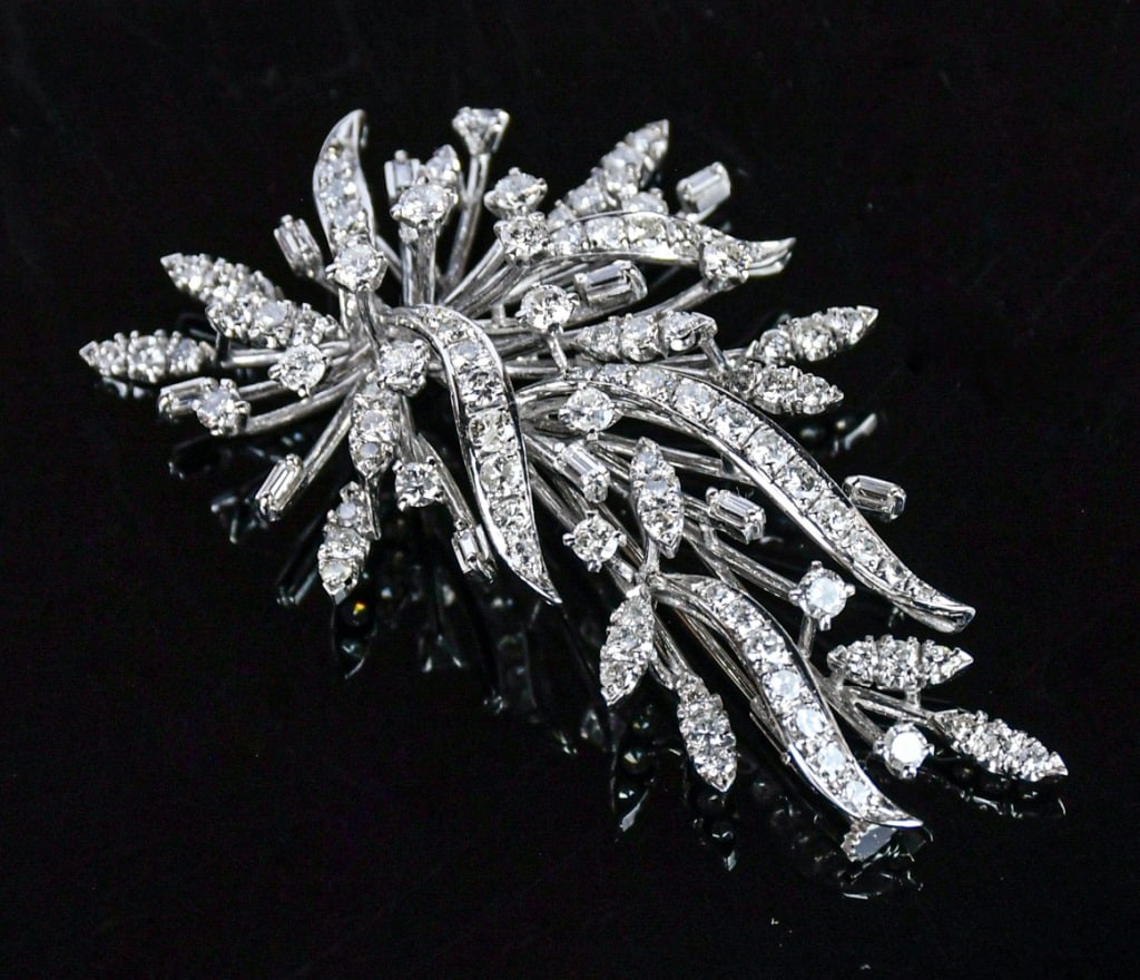 A 18K White Gold Diamond Brooch: One stamped 18K white gold casted flower brooch, contains 16 round brilliant cut prong set natural diamonds, L:6.2cm. Comes with certificate. 18K白金鑲天然鑽胸