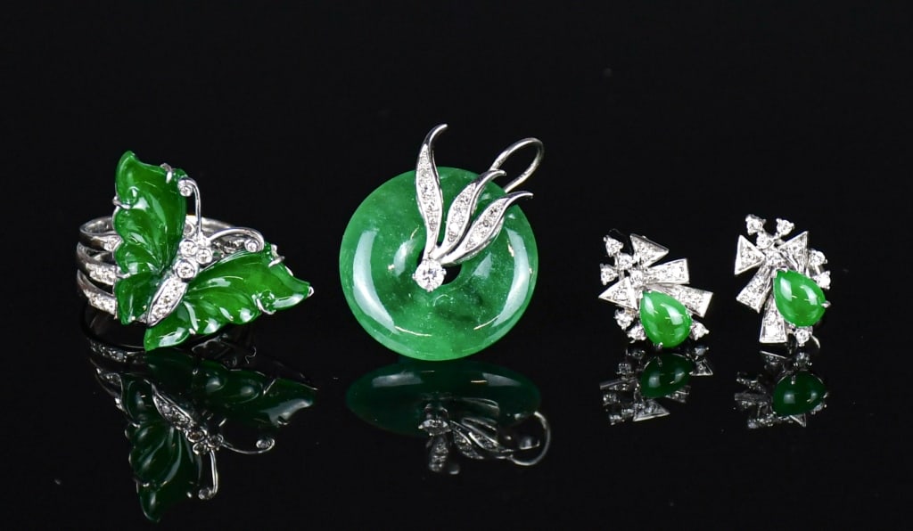 S/4PCs of White Gold Diamonds & Jadeite Jewelry: Comprising a jadeite disc, mounted with a stylized foliate and ribbon bail set with brilliant-cut diamonds, anchoring a larger central brilliant-cut diamond within the center aperture; a butterfly rin