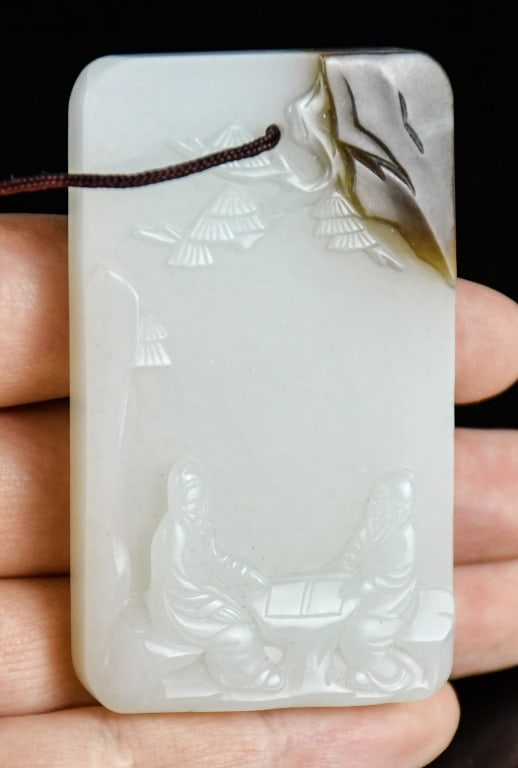 A White Jade Incised Plaque Republican: A white jade plaque with one side carved with figural story, while the other side with inscription, the stone overall in white color tone with russet inclusions. 3.8x6.3cm 民國 人