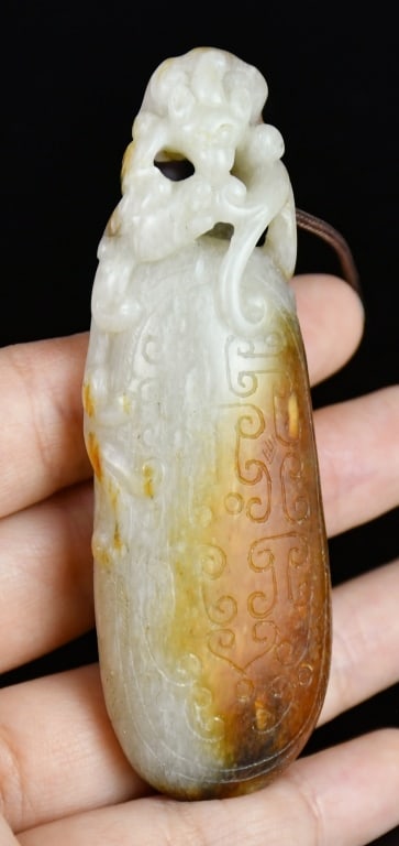 An Archaistic Jade Dragon Carving Qing: A jade carving as a handle or ax, with dargon finial, the stone overall in pale celadon color with large part russet to moss green inclusion. L:8.3cm 清 高古風格青&