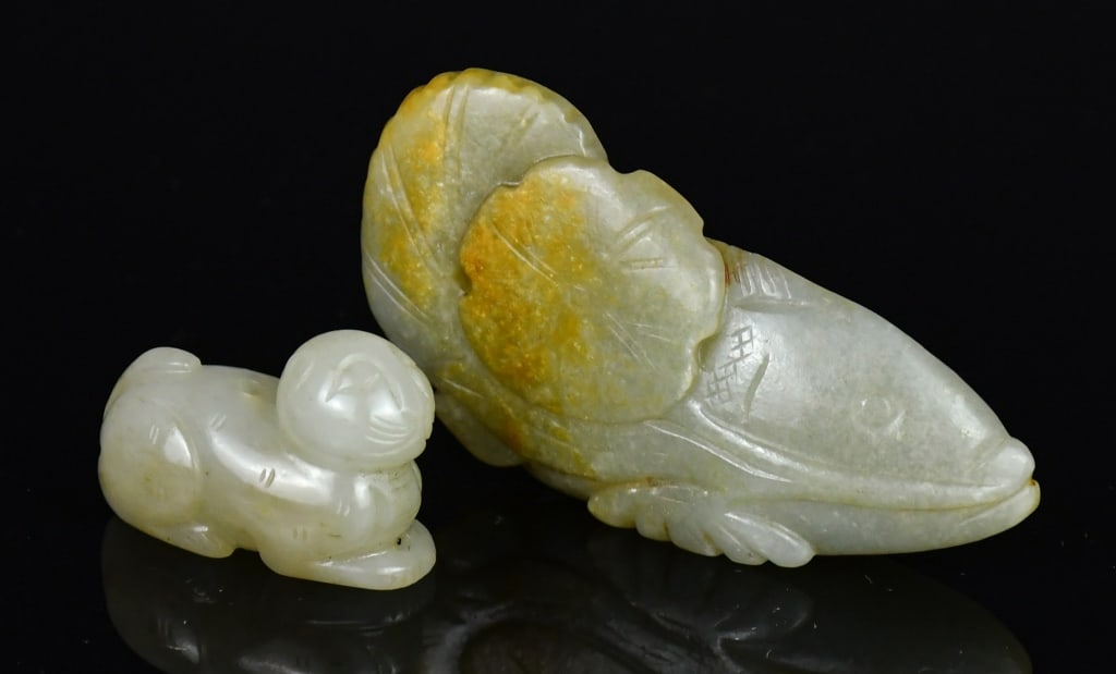 A Jade Fish Ornament & Jade Carved Beast Qing: Comprising a jade fish (7.5x3.6cm) holding a lotus leaf in its mouth and a recumbent cat (3.6x2.5cm), both in celadon tone with russet inclusion. 清 青玉雕魚形ü