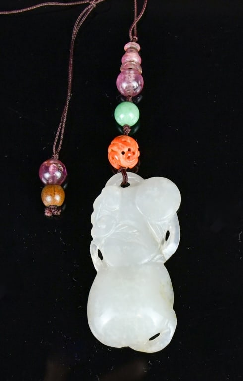 A White Jade Carved Lingzhi Pendant Qing: Carved as a double Lingzhi, the pendant overall in rice white color tone, L:5.2cm. With some decorated beads. 清 白玉雙靈芝掛件
