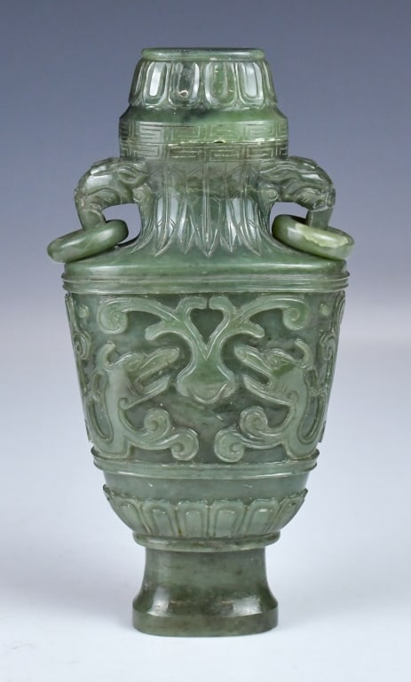 A Carved Archaize Jade Vase & Cover: The flattened ovoid vase is carved in low relief with archaic Kui dragon and scrollwork bands. Two mythical beast flanks the neck handles suspending loose rings, rising to a slightly tapered rim. The