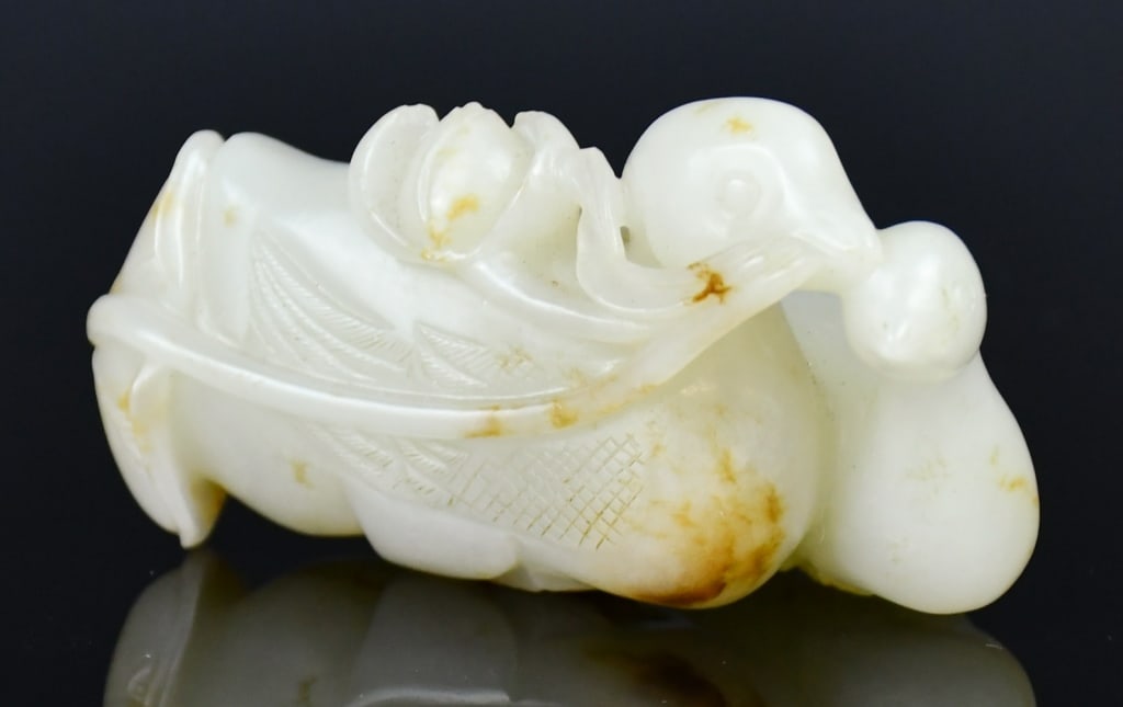 A Jade Carved Double Mandarin Ducks Qing: Double mandarin ducks carved from a celadon jade stone with russet speckles, L:6.7cm 清 寶鴨叼蓮白玉雕把件