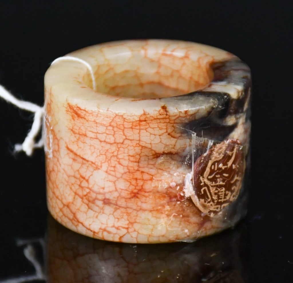 A Jade Thumb Ring Qing: Of cylindrical form, the surface with red veins and russet suffusions, H: 2.4cm, D: 2.1cm. 清 玉扳指 Click here for natural