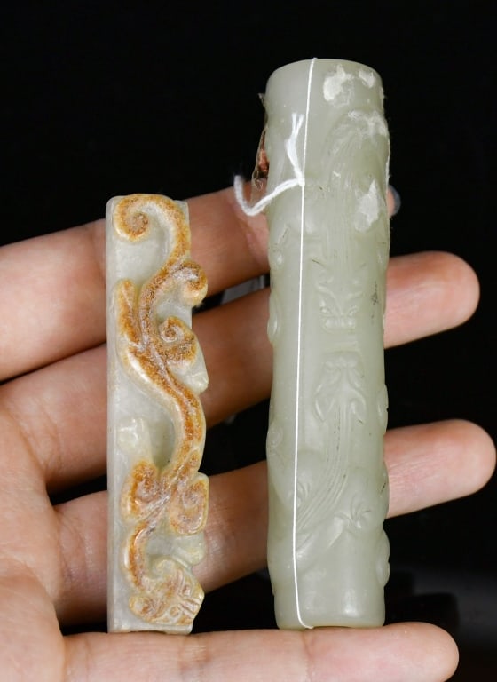 A Group of 2 Jade Plume Holders Qing: Comprising of two plume holders, one of celadon jade carved with chilong motifs, the other of white jade with russet inclusions, carved in relief with chilong motifs. Larger L: 8.2cm 清 玉