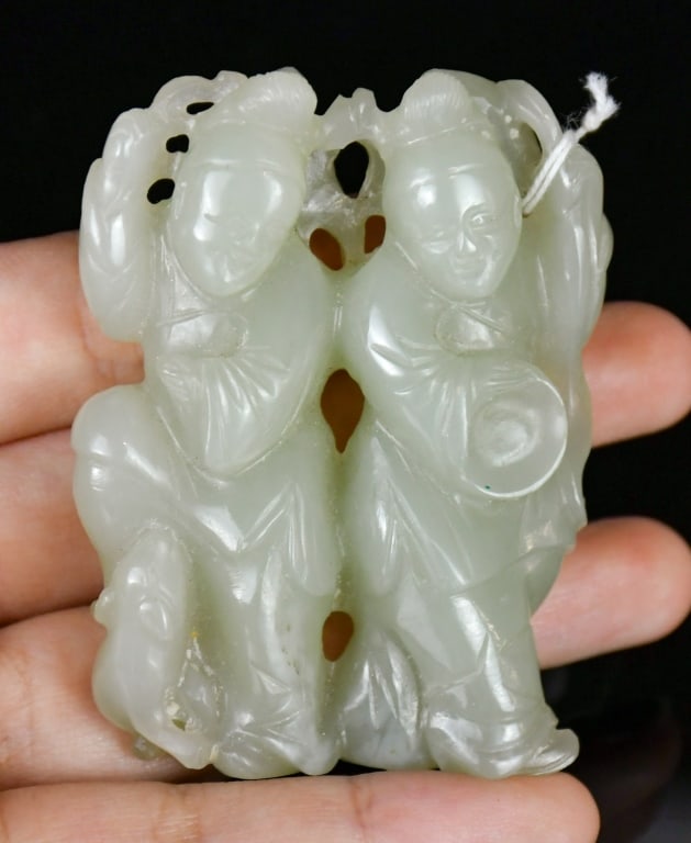 A Celadon Jade Carved Figural Ornament Qing: Carved with two dancing figures, accompanied by a monkey and a dog, the stone of celadon tone. 4.8x6.1cm 清 青白玉雕雙人物把件