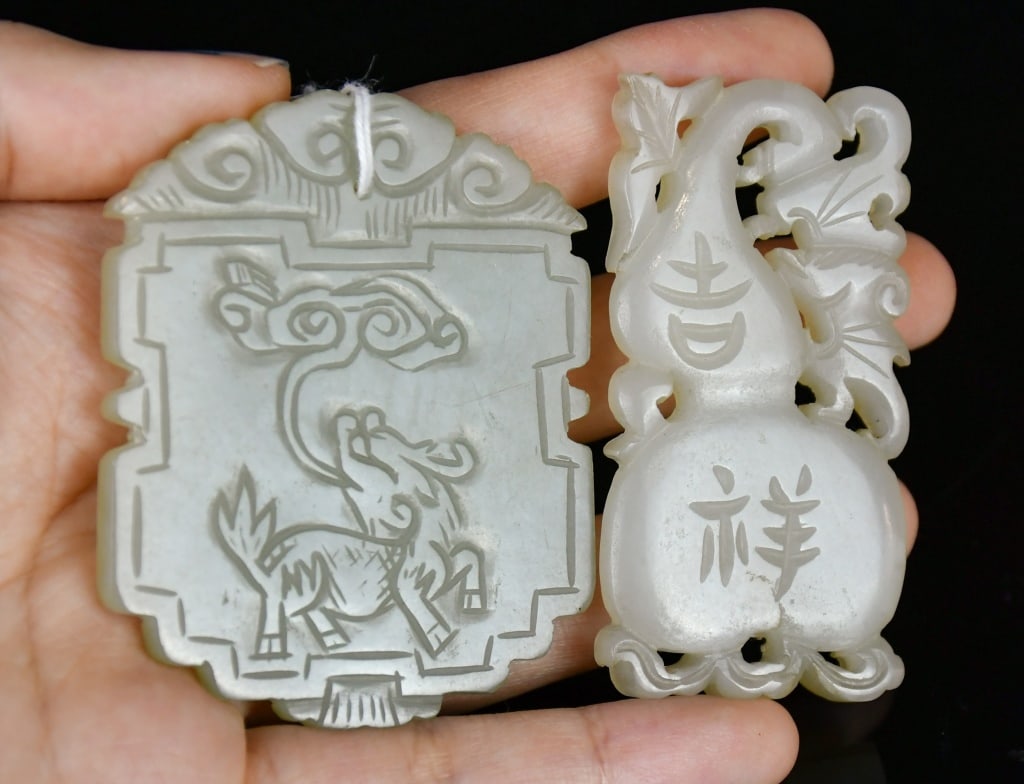 A Group of 2 White Jade Plaques Qing: Comprising a celadon jade carving of a mythical beast holding lingzhi, the reverse carved with geometric motifs; together with an openwork white jade carving in the form of a double gourd, carved with