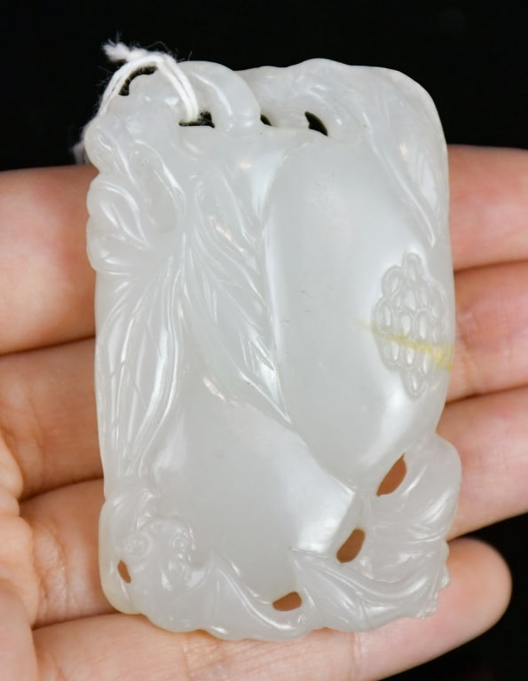 A White Jade Carved Pomegranate & Bat Plaque Qing: A white jade carving of bats perched upon pomegranates, the stone overall in white tone. 5.8x3.6cm 清 白玉雕多子多福牌
