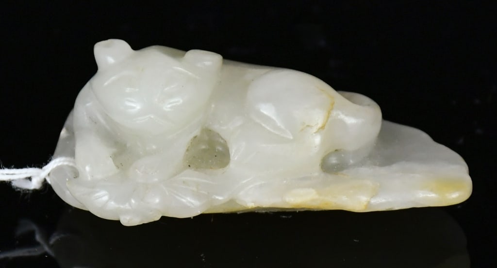 A White Jade Carved Beast Qing: Carved as a recumbent mythical beast on a piece of leaf, the stone of celadon-white tone. 5.4x3.5cm 清 白玉雕瑞獸把件