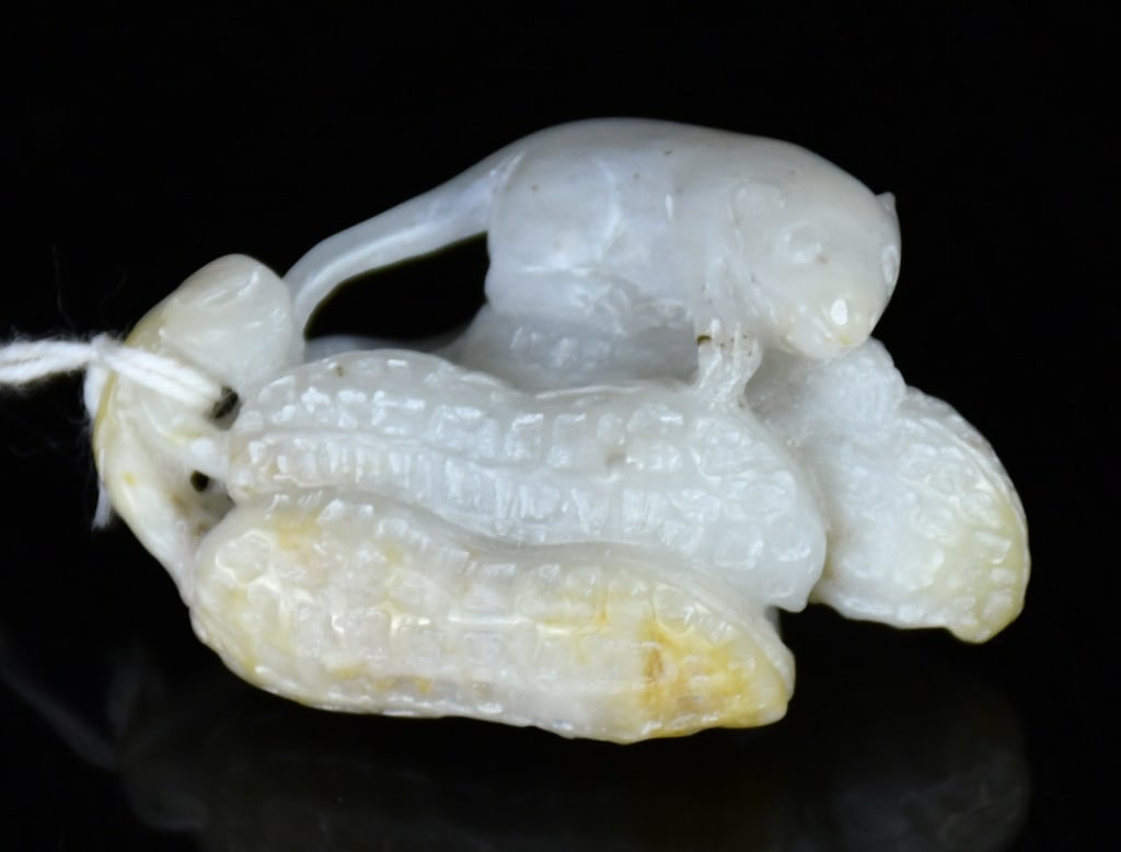 A White Jade Carved Mice & Peanuts Republican: Carved as two mice atop a cluster of peanuts, the stone of white tone with russet inclusions. 3.8x2.8cm 民國 白玉雕雙鼠花生把件
