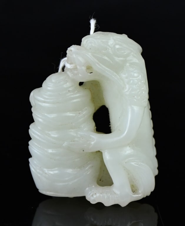 A White Jade Carved Dragon Pendant Qing: Carved as a dragon clambering beside a bamboo shoot, the stone of white tone. 4.8x3.7cm 清 白玉雕龍竹紋把件