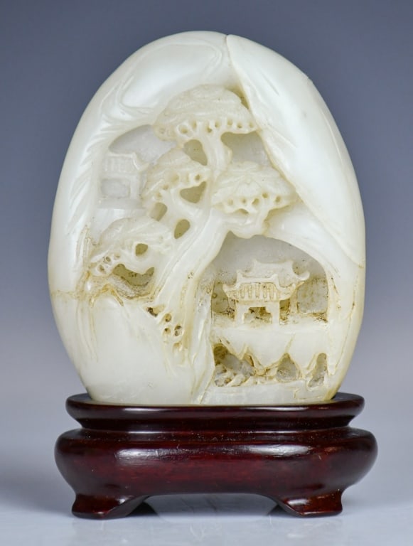 A White Jade Carved Boulder w/Std Republican: Carved and reticulated as landscape scenes on both side, the stone overall in white tone with russet inclusions, H:9cm. 民國 白玉雕山水紋山子