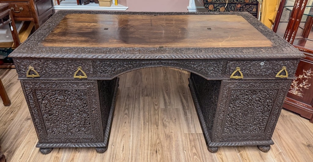 Hardwood HighRelief Carved Executive Desk Republic: A hardwood executive desk that consists of two bases with drawers and a large tabletop. All exterior panels are carved in high-relief patterns, only the desk top remains uncarved. Comes with a glass
