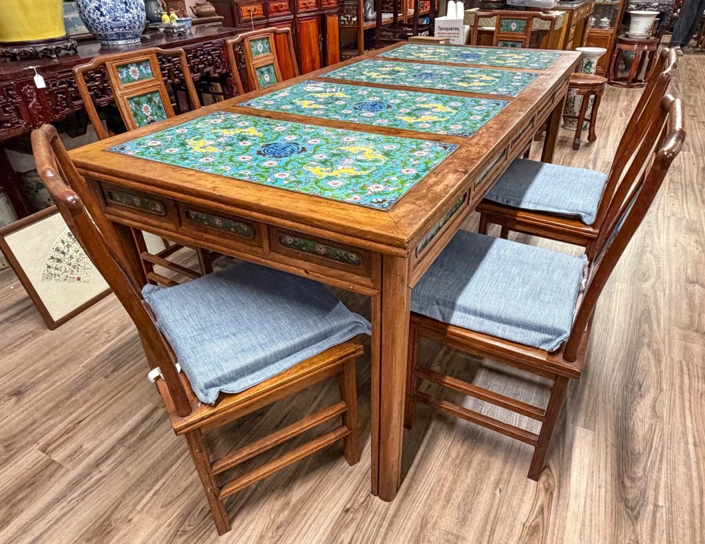 7Pcs Hardwood & Cloisonn?Enamel Dining Set 20thCc: Comprising an extendable rectangular table and six matching chairs, each inset with cloisonn?enamel plaques decorated with shou medallions, bats and scrolling floral vines, all reserved on a