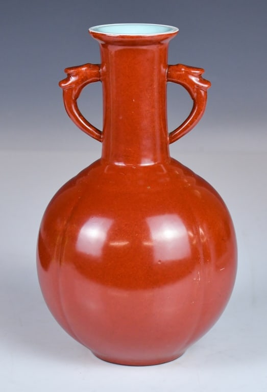 An Iron Red Glazed Handled Vase Republican: Of elegant ovoid shape rising to a slender neck with a flared rim, flanked by two stylized, angled handles. Covered overall in a rich, monochrome iron red glaze, H:21.5cm 民國 礬 