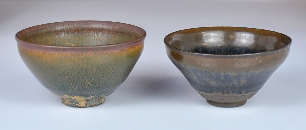 A Pair of Jian Ware Tea Bowls: Comprising two Jian ware tea bowls, each of conical form rising from a short foot, covered overall with a dark brown glaze. H: 6.7cm, D: 12.8cm 高古風格建盞對