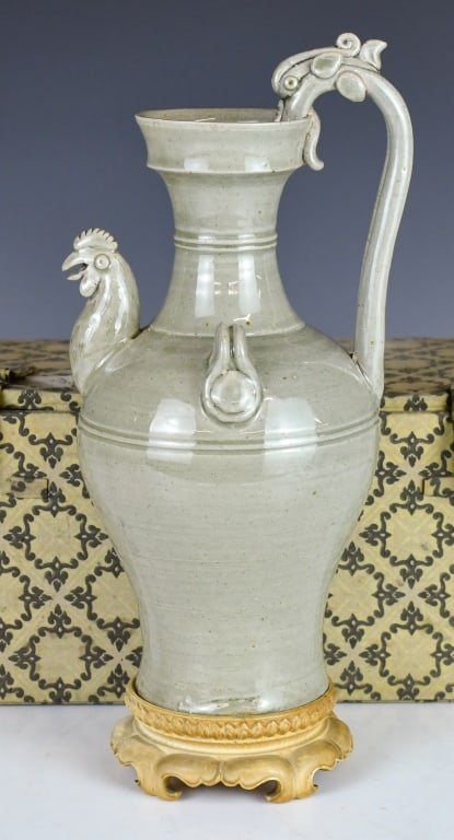 Song to Yuan Lrg Celadon-Glazed Chicken-Head Ewer: Potted with a ovoid body tapering to a slightly flared foot. The shoulders are set with a prominent modeled chicken-head spout with an open beak, balanced on the opposite side by a arching dragon-form