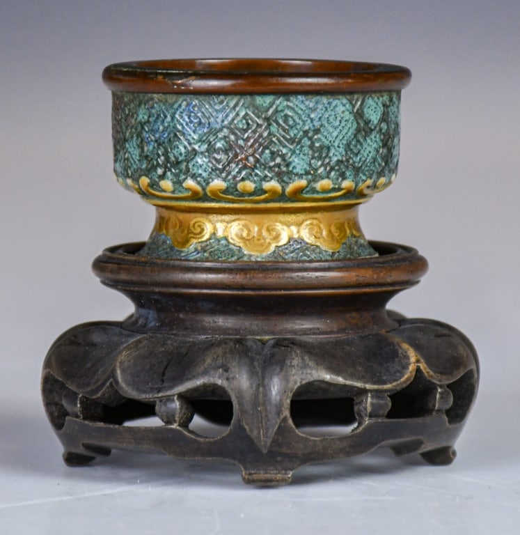 An Archaistic Gilt Porcelain Cup Qianlong Mk w/Std: Of cylindrical form, the exterior decorated in an archaistic style with geometric motifs and ruyi scrolls reserved on a cyan ground, heightened with gilt decoration. H:3.2cm, D: 4.8cm 仿青