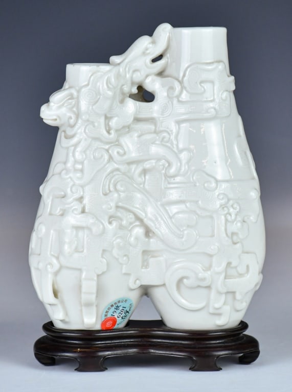 A Blanc-De-Chine Double Vase w/Std Qing: Exquisitely modeled as a conjoined twin-vase of asymmetrical form, the vessel is masterfully enveloped in high relief with a spirited Chilong. Applied overall with a characteristic creamy white glaze